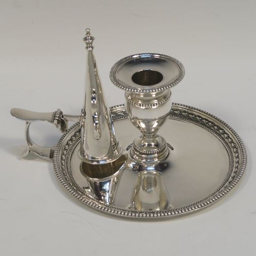 A very pretty Antique Victorian Sterling Silver chamber-stick, having a plain body with a round base, a cast plain scroll side-handle, an original removable dunce-cap extinguisher, an original removable nozzle, and with applied floral and bead-edged borders. This beautiful silver chamberstick was made by James Dixon and Sons of Sheffield of Sheffield in 1900. The dimensions of this fine hand-made antique silver chamberstick are diameter 13.5 cms (5.25 inches), height 9.5 cms (3.75 inches), and it weighs approx. 258g (8.3 troy ounces).   