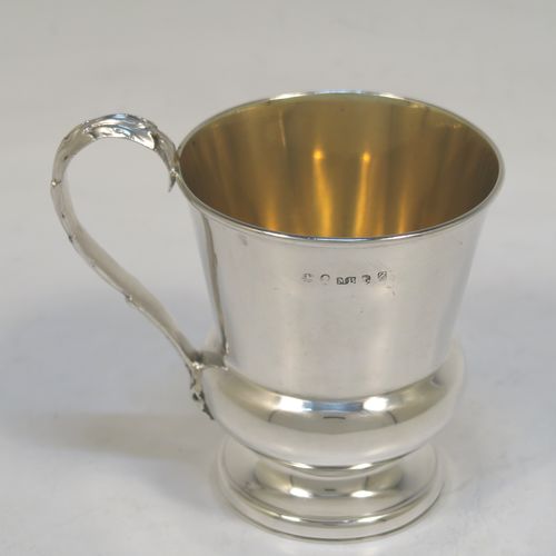 A handsome Antique Georgian Sterling Silver christening mug, having a plain round bellied body with a gold-gilt interior, an acanthus leaf scroll handle, and sitting on a pedestal foot. This elegant antique silver christening mug was made by Matthew Boulton of Birmingham in 1823. The dimensions of this fine hand-made antique silver christening mug are height 9.5 cms (3.75 inches), length 10 cms (4 inches), and it weighs approx. 128g (4 troy ounces).  