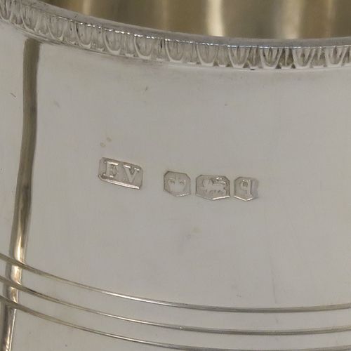 A very elegant Sterling Silver Georgian style christening mug, having a plain round body with a band of hand-chased reeded decoration, an applied egg and dart top border, a scroll handle with flat top, and sitting on a flat base. This handsome silver christening mug was made by Emile Viner of Sheffield in 1933. The dimensions of this fine hand-made silver christening mug are height 8 cms (3 inches), length 10 cms (4 inches), and it weighs approx. 137g (4.4 troy ounces).   