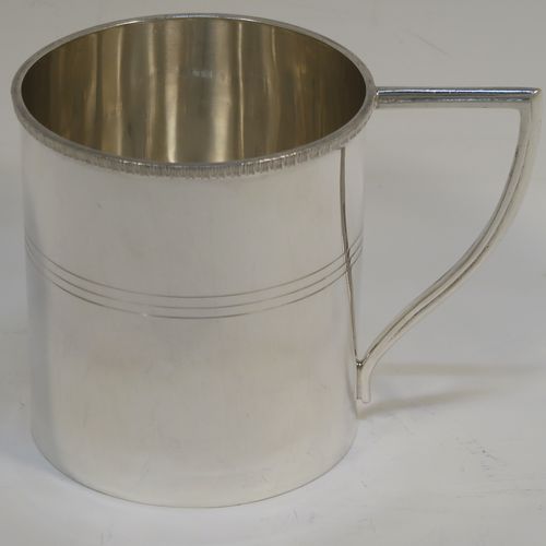 A very elegant Sterling Silver Georgian style christening mug, having a plain round body with a band of hand-chased reeded decoration, an applied egg and dart top border, a scroll handle with flat top, and sitting on a flat base. This handsome silver christening mug was made by Emile Viner of Sheffield in 1933. The dimensions of this fine hand-made silver christening mug are height 8 cms (3 inches), length 10 cms (4 inches), and it weighs approx. 137g (4.4 troy ounces).   