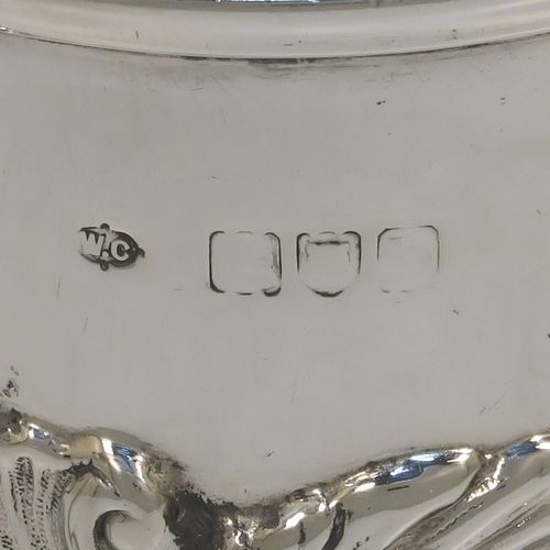 A pretty Antique Victorian Sterling Silver christening mug, having a round straight sided body with a reeded top border, a lower band of hand-chased scroll and floral decoration, a plain loop side-handle, and all sitting on a flat base. This beautiful antique silver christening mug was made by William Comyns of London in 1897. The dimensions of this fine hand-made antique silver christening mug are height 9 cms (3.5 inches), diameter at lip 7.5 cms (3 inches), and it weighs approx. 168g (5.4 troy ounces).  