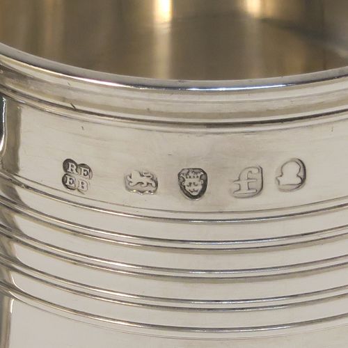 An elegant Antique Georgian Sterling Silver christening mug, having a plain round body with two bands of hand-chased reeded decoration, a scroll handle with an applied anthemion leaf thumb-piece, and sitting on a flat base. This handsome antique silver christening mug was made by Emes and Barnard in London in 1821. The dimensions of this fine hand-made antique silver christening mug are height 7.5 cms (3 inches), length 9 cms (3.5 inches), and it weighs approx. 115g (3.7 troy ounces).  