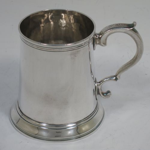 A very handsome Antique Georgian Sterling Silver christening mug, having a plain round body with applied reeded borders, a scroll handle, and sitting on a collet foot. Made by Walter Brind of London in 1770. The dimensions of this fine hand-made antique silver christening mug are height 9 cms (3.5 inches), length 11 cms (4.25 inches), and it weighs approx. 175g (5.6 troy ounces).    