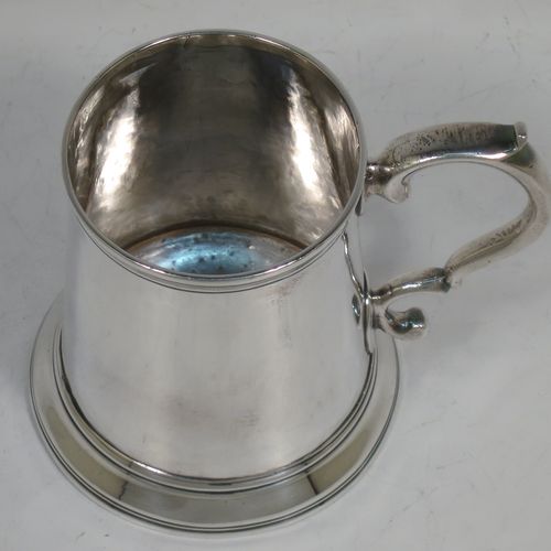 A very handsome Antique Georgian Sterling Silver christening mug, having a plain round body with applied reeded borders, a scroll handle, and sitting on a collet foot. Made by Walter Brind of London in 1770. The dimensions of this fine hand-made antique silver christening mug are height 9 cms (3.5 inches), length 11 cms (4.25 inches), and it weighs approx. 175g (5.6 troy ounces).    