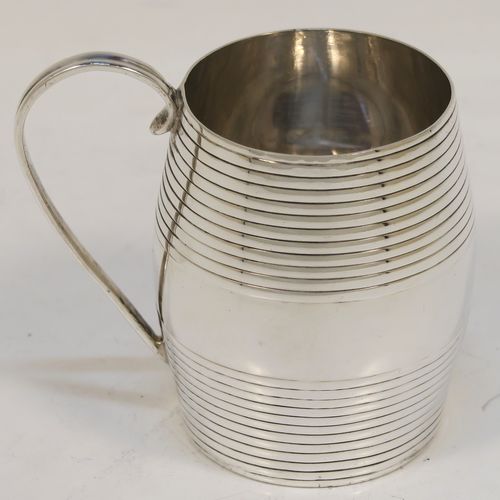 An elegant Antique Georgian Sterling Silver christening mug, having a round barrel-shaped body with two bands of hand-chased reeded decoration, a scroll side-handle, and sitting on a flat base. This handsome antique silver christening mug was made by James Jennings of London in 1780. The dimensions of this fine hand-made antique silver christening mug are height 6.5 cms (2.75 inches), length 8 cms (3 inches), and it weighs approx. 71g (2.3 troy ounces).  