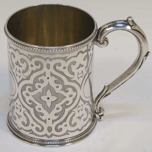 A very pretty Antique Victorian Sterling Silver christening mug, having a round body with straight sides, with hand-engraved scroll decoration, a gold-gilt interior, applied bead-edged borders, a scroll handle, and sitting on a flat base. This beautiful antique silver christening mug was made by Henry Holland of London in 1868. The dimensions of this fine hand-made antique silver mug are height 8 cms (3 inches), diameter at lip 6 cms (2.3 inches), and it weighs approx. 111g (3.6 troy ounces).   