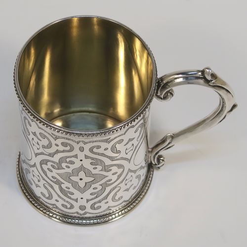 A very pretty Antique Victorian Sterling Silver christening mug, having a round body with straight sides, with hand-engraved scroll decoration, a gold-gilt interior, applied bead-edged borders, a scroll handle, and sitting on a flat base. This beautiful antique silver christening mug was made by Henry Holland of London in 1868. The dimensions of this fine hand-made antique silver mug are height 8 cms (3 inches), diameter at lip 6 cms (2.3 inches), and it weighs approx. 111g (3.6 troy ounces).   