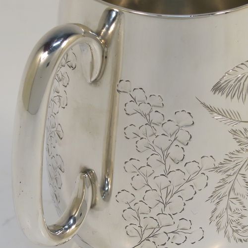 A very pretty Antique Victorian Sterling Silver christening mug, having a round body with straight tapering sides and tucked under belly, with hand-engraved ferns and gingko leaves decoration, a plain loop handle, and all sitting on a pedestal foot. This beautiful silver christening mug was made by Thomas Goodfellow of London in 1888. The dimensions of this fine hand-made antique silver christening mug are height 9.5 cms (3.75 inches), diameter at lip 6 cms (2.25 inches), and it weighs approx. 147g (4.7 troy ounces).  