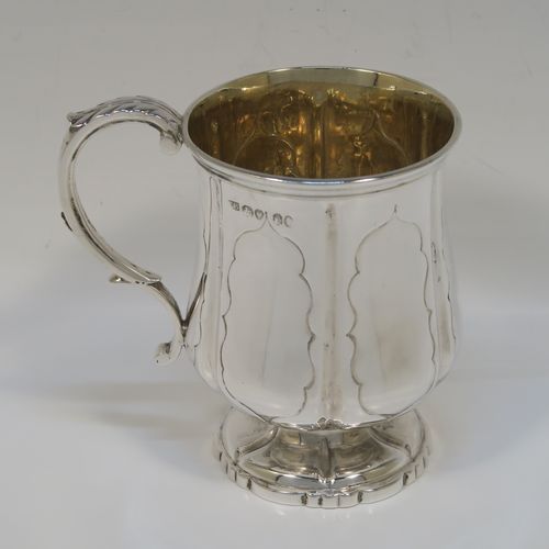 An elegant Antique early Victorian Sterling Silver christening mug, having a bellied body with hand-chased fluted and panelled decoration, a scroll handle with anthemion leaf thumb-piece, a gold-gilt interior, and all sitting on a pedestal foot. This handsome silver christening mug was made by the Edward Burton of London in 1837. The dimensions of this fine hand-made antique silver christening mug are height 10 cms (4 inches), length 10 cms (4 inches), and it weighs approx. 141g (4.5 troy ounces).   