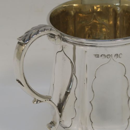 An elegant Antique early Victorian Sterling Silver christening mug, having a bellied body with hand-chased fluted and panelled decoration, a scroll handle with anthemion leaf thumb-piece, a gold-gilt interior, and all sitting on a pedestal foot. This handsome silver christening mug was made by the Edward Burton of London in 1837. The dimensions of this fine hand-made antique silver christening mug are height 10 cms (4 inches), length 10 cms (4 inches), and it weighs approx. 141g (4.5 troy ounces).   