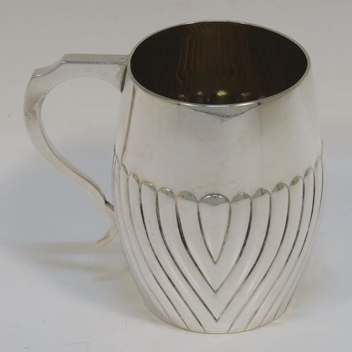 An elegant Antique Victorian Sterling Silver christening mug, having a bellied body with hand-chased half swirl fluted decoration, a scroll handle with flat top, a gold-gilt interior, and all sitting on a flat base. This handsome silver christening mug was made by the Barnard Brothers of London in 1883. The dimensions of this fine hand-made antique silver christening mug are height 9 cms (3.5 inches), length 9.5 cms (3.75 inches), and it weighs approx. 118g (3.8 troy ounces).   