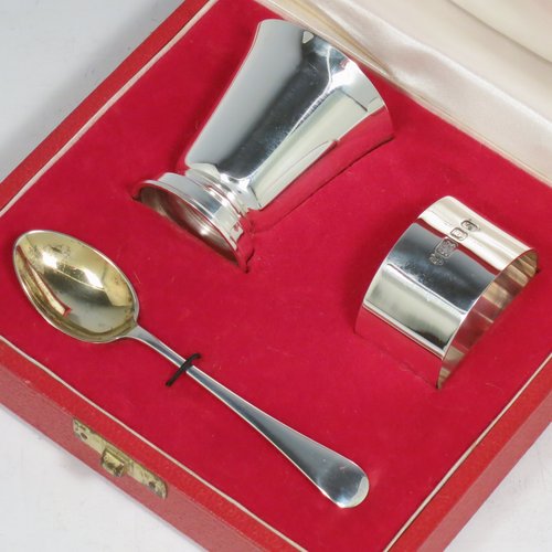 A Sterling Silver christening set, having an egg cup with gold-gilt interior, a spoon with gold-gilt bowl, and a napkin ring. All in a very plain style, and sitting in their original satin and velvet-lined red presentation box. Made by Payne & Son Ltd., of London in 1971/73. The dimensions of this fine hand-made silver christening set are length of spoon 11 cms (4.3 inches), height of egg cup 6 cms (2.25 inches), diameter of napkin ring 4.5 cms (1.75 inches), and the total weight is approx. 97g (3 troy ounces).   