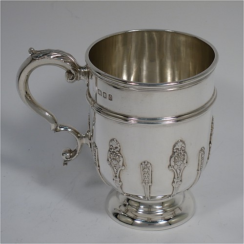 A Sterling Silver christening set consisting of a christening mug with applied strap-work decoration and a scroll handle, and a matching fork and two spoons in the Rattail Hanoverian pattern, all in a cream satin and blue velvet-lined presentation box. The christening mug made in London 1919 and the cutlery from 1895 to 1928. The dimensions of this fine hand-made antique silver christening set are height of mug 9 cms (3.7 inches), length of fork 16 cms (6.25 inches), and with a total weight of approx. 280g (9 troy ounces).   