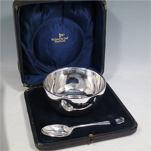 A Sterling Silver christening set, consisting of a plain round baluster bowl sitting on a flat base and a plain Hanoverian pattern spoon, all sitting in an original dark blue satin and velvet-lined presentation box. Made by Walker & Hall of Sheffield in 1931. The dimensions of this fine hand-made silver christening set are length of spoon 14 cms (5.5 inches), diameter of bowl 11 cms (4.3 inches), and the total weight is approx. 185g (6 troy ounces).    