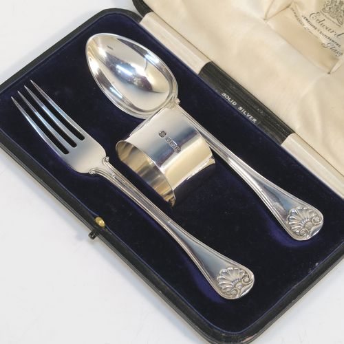 A very handsome Antique Sterling Silver christening set consisting of a plain round napkin ring, a spoon and fork in the double-struck Old English, Thread and Shell pattern, and all in their original cream satin and dark blue velvet-lined presentation box. This elegant silver christening set was mad by Martin Hall and Co., of Sheffield in 1912. The dimensions of this fine hand-made antique silver christening set are length of spoon and fork 16 cms (6.3 inches), diameter of napkin ring 4.5 cms (1.75 inches), and it has a total weight of approx. 124g (4 troy ounces).   