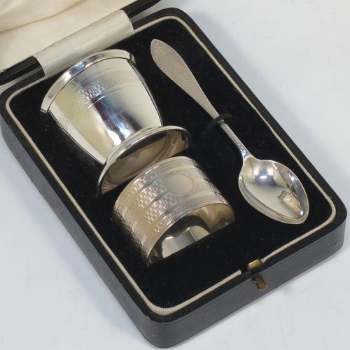 A handsome Art Deco style Sterling Silver three-piece christening set, consisting of a napkin ring, egg cup, and spoon, all with engine-turned decoration, and in their original cream satin and black velvet-lined presentation box. Made by William Base and Sons of Sheffield in 1925. The dimensions of this fine hand-made silver christening set are length of spoon 11 cms (4.3 inches), diameter of napkin ring 4 cms (1.6 inches), height of egg cup 4.5 cms (1.75 inches), and the total weight is approx. 66g (2.1 troy ounces).  