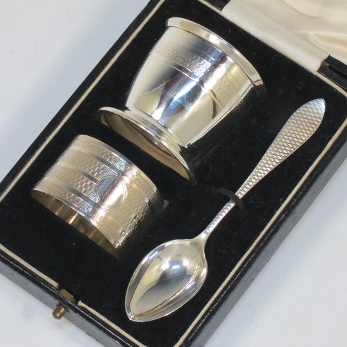 A handsome Art Deco style Sterling Silver three-piece christening set, consisting of a napkin ring, egg cup, and spoon, all with engine-turned decoration, and in their original cream satin and black velvet-lined presentation box. Made by William Base and Sons of Sheffield in 1925. The dimensions of this fine hand-made silver christening set are length of spoon 11 cms (4.3 inches), diameter of napkin ring 4 cms (1.6 inches), height of egg cup 4.5 cms (1.75 inches), and the total weight is approx. 66g (2.1 troy ounces).  