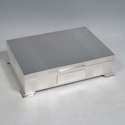 Sterling silver Art Deco style cigarette / cigar table box, having a very plain rectangular body with straight sides, hinged lid with thumb-piece, with engine-turned bands on inside border and lid, a wooden cedar-lined interior, and all sitting on four stepped corner feet. Made by J. B. Chatterley & Sons Ld., of Birmingham in 1955. The dimensions of this fine hand-made silver table box are length 17 cms (6.75 inches), height 6 cms (2.3 inches), and width 9.5 cms (3.75 inches).