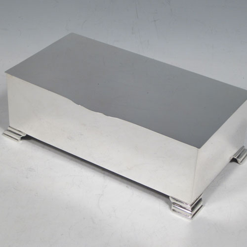 Sterling silver Art Deco style cigarette / cigar table box, having a very plain rectangular body with straight sides, hinged lid with thumb-piece, with engine-turned bands on inside border and lid, a wooden cedar-lined interior, and all sitting on four stepped corner feet. Made by J. B. Chatterley & Sons Ld., of Birmingham in 1955. The dimensions of this fine hand-made silver table box are length 17 cms (6.75 inches), height 6 cms (2.3 inches), and width 9.5 cms (3.75 inches).