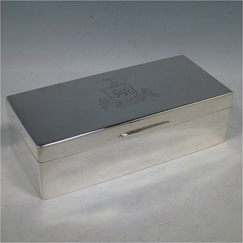 A Sterling Silver cigarette / cigar table box, having a plain rectangular body, with nice rounded corners, a hinged lid having an applied thumb-piece, and a gold-gilt and cedar wood-lined interior with two internal dividers. Made by Robert Comyns of London in 1932. The dimensions of this fine hand-made silver table box are length 19 cms (7.5 inches), width 9 cms (3.5 inches), and height 5.5 cms (2.25 inches). Please note that this item is crested.