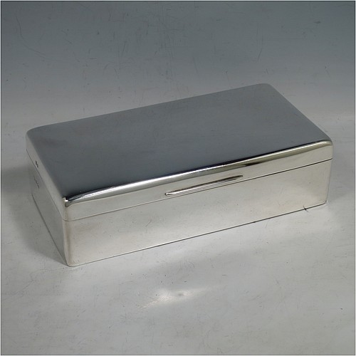 A Sterling Silver cigarette or cigar table box, having a plain rectangular body with nice rounded corners, a hinged lid having an applied thumb-piece, a gold-gilt interior to the lid, and a cedar wood-lined interior to the base, with a removable divider. Made by Alexander Clarke of London in 1925. The dimensions of this fine hand-made silver table box are length 17.5 cms (7 inches), width 9 cms (3.5 inches), and height 5 cms (2 inches).    