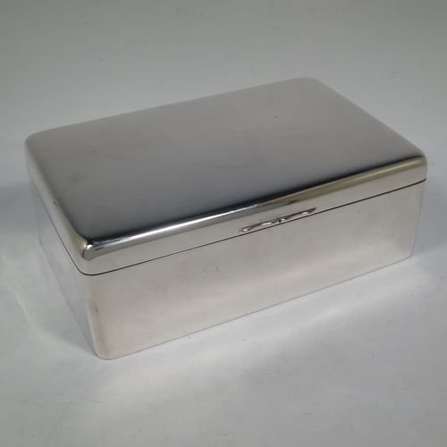 A large and handsome Antique Victorian Sterling Silver cigarette / cigar table box, having a plain rectangular body with nice rounded corners, a hinged lid having an applied thumb-piece, and a cedar wood-lined interior to the base, with a removable divider. Made by A. and J. Zimmerman of Birmingham  in 1898. The dimensions of this fine hand-made antique silver table cigar or cigarette box are length 23.5 cms (9.25 inches), width 15 cms (6 inches), and height 8 cms (3 inches).    