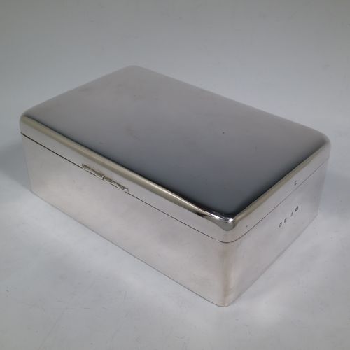 A large and handsome Antique Victorian Sterling Silver cigarette / cigar table box, having a plain rectangular body with nice rounded corners, a hinged lid having an applied thumb-piece, and a cedar wood-lined interior to the base, with a removable divider. Made by A. and J. Zimmerman of Birmingham  in 1898. The dimensions of this fine hand-made antique silver table cigar or cigarette box are length 23.5 cms (9.25 inches), width 15 cms (6 inches), and height 8 cms (3 inches).    