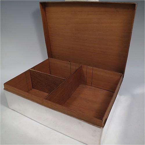 A very large Sterling Silver cigarette or cigar humidor table box, having a plain rectangular body with nice rounded corners, a hinged lid having an applied thumb-piece, a cedar wood-lined interior to lid and base, with two removable dividers. Made in London in 1923. The dimensions of this fine hand-made silver table box are length 30.5 cms (12 inches), width 23 cms (9 inches), and height 10 cms (4 inches). 