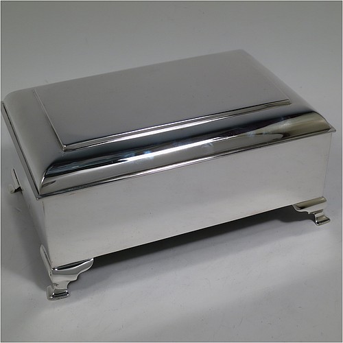 A large and very stylish Antique Edwardian Sterling Silver cigar / cigarette box, having a plain rectangular body, with a stepped and flat-topped hinged lid, a cedar wood-lined interior with internal divider, and all sitting on four cast stepped feet. Made by A. & J. Zimmerman of Birmingham in 1903. The dimensions of this fine hand-made antique silver table box are length 20 cms (8 inches), width 13.5 cms (5.25 inches), and height 9 cms (3.5 inches).   