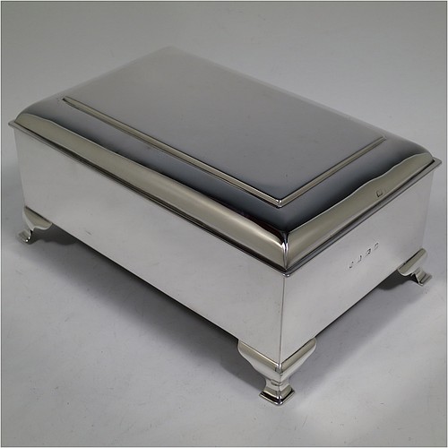 A large and very stylish Antique Edwardian Sterling Silver cigar / cigarette box, having a plain rectangular body, with a stepped and flat-topped hinged lid, a cedar wood-lined interior with internal divider, and all sitting on four cast stepped feet. Made by A. & J. Zimmerman of Birmingham in 1903. The dimensions of this fine hand-made antique silver table box are length 20 cms (8 inches), width 13.5 cms (5.25 inches), and height 9 cms (3.5 inches).   