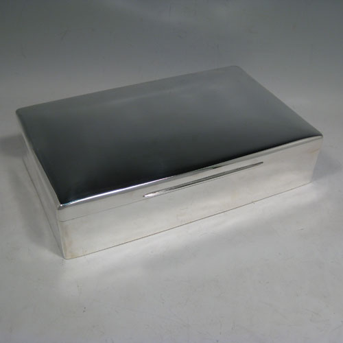 Sterling silver large cigar table box, having a plain rectangular body, a slightly domed and hinged lid with thumbpiece, and cedar wood-lined interior with two removable dividers. Made by Alexander Clarke of London in 1927. The dimensions of this fine silver cigar box are length 25.5 cms (10 inches), width 15 cms (6 inches), and height 6.5 cms (2.5 inches).    