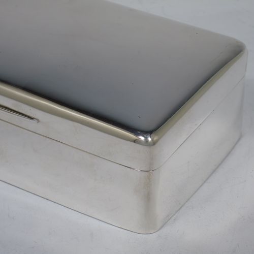 A handsome Antique Ewarian Sterling Silver cigarette / cigar table box, having a plain rectangular body with nice rounded corners, a hinged lid having an applied thumb-piece and gold-gilt inside, and a cedar wood-lined interior to the base, with a removable divider. Made by Goldsmiths and Silversmiths of London in 1909. The dimensions of this fine hand-made antique silver table cigar or cigarette box are length 18 cms (7 inches), width 9 cms (3.5 inches), and height 5 cms (2 inches).    