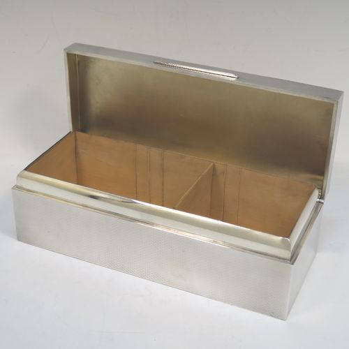 A very elegant Antique Sterling Silver cigarette / cigar table box, having a rectangular body with geometrically designed engine-turned decoration, a hinged lid with a Greek-Key border, an applied thumb-piece, a gold-gilt and cedar wood-lined interior, and all sitting on a flat base. This beautiful silver box was made by William Neale of Birmingham in 1923. The dimensions of this fine hand-made antique silver table box are length 23 cms (9 inches), width 9 cms (3.5 inches), and height 7 cms (2.75 inches). Please note that there is a slight imperfection on the lid surface due to the removal of a dent in the engine turning.  