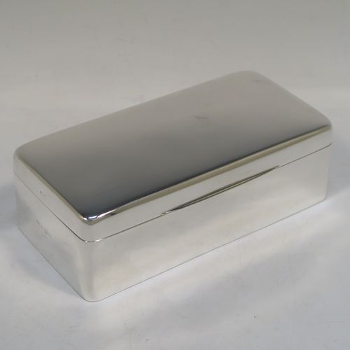 A very handsome Antique Sterling Silver cigarette / cigar table box, having a plain rectangular body with nice rounded corners, a hinged lid having an applied thumb-piece, with a gold-gilt and cedar wood-lined interior to the base, with a removable divider. This elegant antique silver table box was made by Robert Comyns of Birmingham in 1918. The dimensions of this fine hand-made antique silver table cigar or cigarette box are length 18 cms (7 inches), width 9 cms (3.5 inches), and height 6 cms (2.3 inches).   