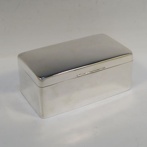 A very elegant Antique Sterling Silver cigarette or cigar table box, having a plain rectangular body with nice rounded corners, a hinged lid having an applied thumb-piece, with a cedar wood-lined interior to the base and a removable divider. This elegant antique silver table box was made by A. and J. Zimmerman of Birmingham in 1913. The dimensions of this fine hand-made antique silver table cigar or cigarette box are length 17 cms (6.75 inches), depth 10 cms (4 inches), and height 7 cms (2.75 inches).   