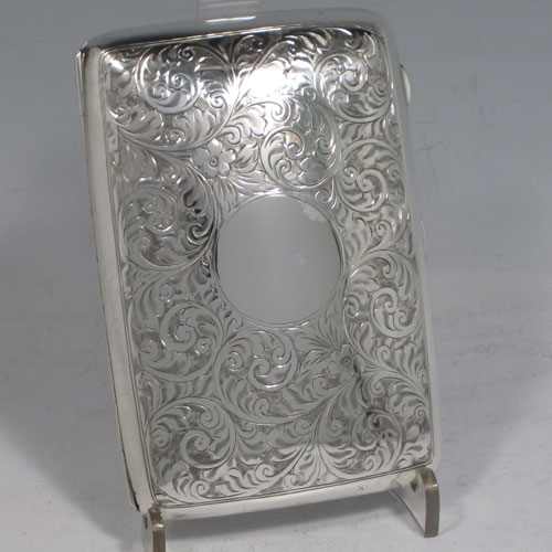 Sterling silver cigarette / cigarello case, having a rectangular shaped body with rounded edges, hand-engraved floral style decoration, central vacant cartouche, and thumb-piece with catch. Made by Henry Miller of Birmingham in 1921. The dimensions of this fine hand-made silver cigar case are length 11.5 cms (4.5 inches), width 8 cms (3 inches), depth 2.5 cms (1 inch), and the weight is approx. 147g (4.7 troy ounces).