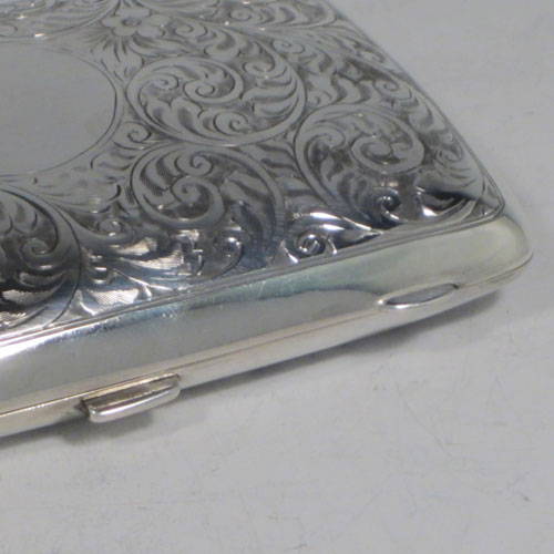 Sterling silver cigarette / cigarello case, having a rectangular shaped body with rounded edges, hand-engraved floral style decoration, central vacant cartouche, and thumb-piece with catch. Made by Henry Miller of Birmingham in 1921. The dimensions of this fine hand-made silver cigar case are length 11.5 cms (4.5 inches), width 8 cms (3 inches), depth 2.5 cms (1 inch), and the weight is approx. 147g (4.7 troy ounces).