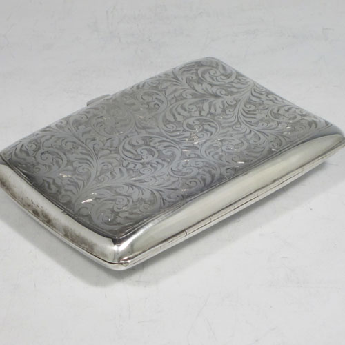 Sterling silver cigarette / cigarello case, having a rectangular shaped body with rounded edges, hand-engraved floral style decoration, central vacant cartouche, and thumb-piece with catch. Made by Henry Miller of Birmingham in 1921. The dimensions of this fine hand-made silver cigar case are length 11.5 cms (4.5 inches), width 8 cms (3 inches), depth 2.5 cms (1 inch), and the weight is approx. 147g (4.7 troy ounces).