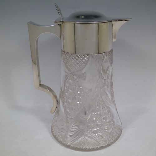 A very handsome and large Antique Victorian Sterling Silver and hand-cut crystal lemonade or pimms jug, having a plain round mount, a hinged lid with a pierced thumb-piece, a plain square cross-section handle, a sparrow-beak style spout, together with an original internal glass tube for crushed ice (with silver  handle and bayonet-fit lift-off lid), a hand-cut crystal body with lobes of hobnail-cut decoration, and all sitting on a flat star-cut base. Made by Streeter and Co. Ltd., of London in 1899. The dimensions of this fine hand-made antique silver and crystal pimms or lemonade jug are height 28 cms (11 inches), length 21 cms (8.25 inches), and diameter at base 17 cms (6.75 inches).   