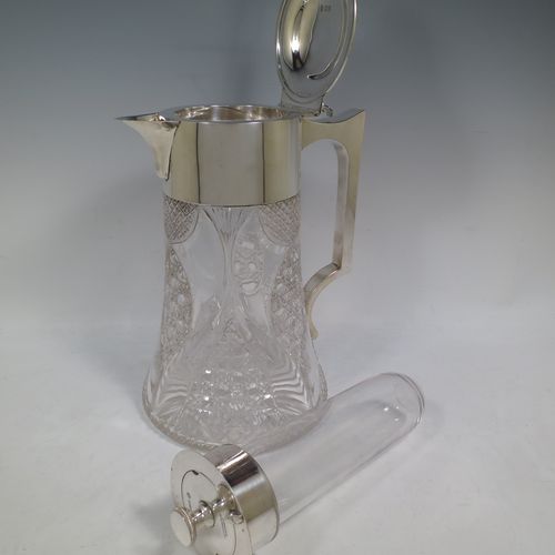 A very handsome and large Antique Victorian Sterling Silver and hand-cut crystal lemonade or pimms jug, having a plain round mount, a hinged lid with a pierced thumb-piece, a plain square cross-section handle, a sparrow-beak style spout, together with an original internal glass tube for crushed ice (with silver  handle and bayonet-fit lift-off lid), a hand-cut crystal body with lobes of hobnail-cut decoration, and all sitting on a flat star-cut base. Made by Streeter and Co. Ltd., of London in 1899. The dimensions of this fine hand-made antique silver and crystal pimms or lemonade jug are height 28 cms (11 inches), length 21 cms (8.25 inches), and diameter at base 17 cms (6.75 inches).   