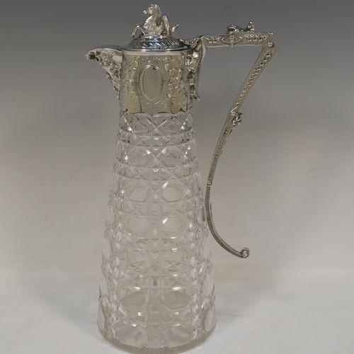 A very pretty Antique Victorian Silver Plated and hand-cut crystal claret jug, having a hand-chased mount with floral decoration and Bacchus face on the spout, a cast Pegasus finial, a scrolled cast handle, and a crystal body with hobnail cut. This beautiful antique silver-plated claret jug was made in ca. 1880. The dimensions of this fine hand-made silver-plated claret jug are height 29 cms (11.5 inches), length 16 cms (6.3 inches).  