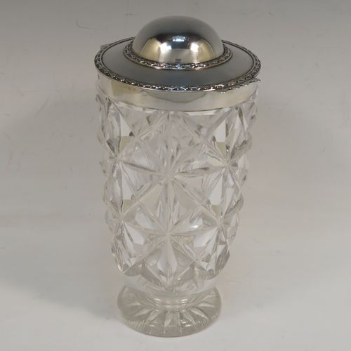 A very unusual and handsome Antique Sterling Silver and hand-cut crystal cocktail mixing jar, having a round crystal body with a hobnail cut, a plain round silver mount and a hinged domed lid with applied floral borders. This elegant silver and crystal cocktail jar was made by Hamilton and Co., of London in 1912. The dimensions of this fine hand-made silver and crystal cocktail mixing jar are height 20.5 cms (8 inches), and diameter at widest point 10 cms (4 inches).  