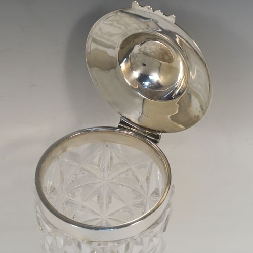 A very unusual and handsome Antique Sterling Silver and hand-cut crystal cocktail mixing jar, having a round crystal body with a hobnail cut, a plain round silver mount and a hinged domed lid with applied floral borders. This elegant silver and crystal cocktail jar was made by Hamilton and Co., of London in 1912. The dimensions of this fine hand-made silver and crystal cocktail mixing jar are height 20.5 cms (8 inches), and diameter at widest point 10 cms (4 inches).  