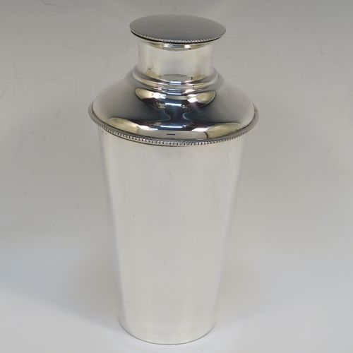 A very handsome Sterling Silver Art Deco cocktail shaker, having a plain round body with tapering sides, with a pull-off lid and interior strainer section, and a bead edge to the main body and lid. This elegant silver cocktail shaker was made by Synyer and Beddoes of Birmingham in 1939. The dimensions of this fine hand-made silver cocktail shaker are height 19 cms (7.5 inches), diameter at widest point 9.5 cms (3.75 inches), and it weighs approx. 329g (10.6 troy ounces).   