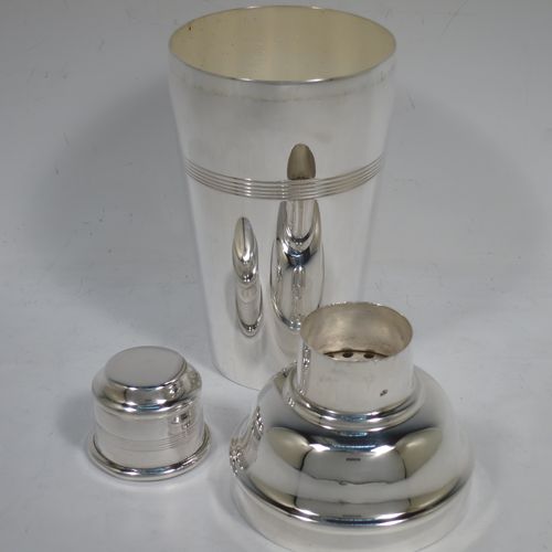 A handsome Silver-Plated Art Deco cocktail shaker, having a plain round body with tapering sides and hand-egraved bands of horizontal reeded decoration, a pull-off lid with knurled border, together with a pull-off strainer section, and the main body with a flat base. Made by Charles Boyton and Sons of Sheffield, England, in ca. 1930. The dimensions of this fine hand-made silver plated cocktail shaker are height 21.5 cms (8.5 inches), diameter at widest point 8.5 cms (3.3 inches).   