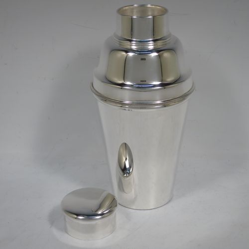 A handsome Silver-Plated Art Deco cocktail shaker, having a plain round body with tapering sides, with a pull-off lid, and strainer section with an applied knurled edge, and the main body with a flat base. Made in Sheffield, England, in ca. 1930. The dimensions of this fine hand-made silver plated cocktail shaker are height 19 cms (7.5 inches), diameter at widest point 9 cms (3.5 inches).    