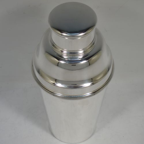 A handsome Silver-Plated Art Deco cocktail shaker, having a plain round body with tapering sides, with a pull-off lid, and strainer section with an applied knurled edge, and the main body with a flat base. Made in Sheffield, England, in ca. 1930. The dimensions of this fine hand-made silver plated cocktail shaker are height 19 cms (7.5 inches), diameter at widest point 9 cms (3.5 inches).    