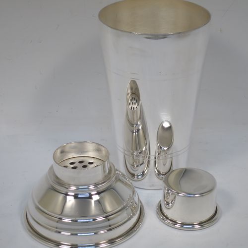 A very stylish Silver-Plated Art Deco cocktail shaker, having a plain round body with tapering sides and hand-chased bands of reeded decoration, a plain round and flat top pull-off lid, and a central removable strainer section. Made in ca. 1930 in Sheffield, England. The dimensions of this fine hand-made silver plated cocktail shaker are height 20 cms (8 inches), and diameter at widest point is 9 cms (3.5 inches).  