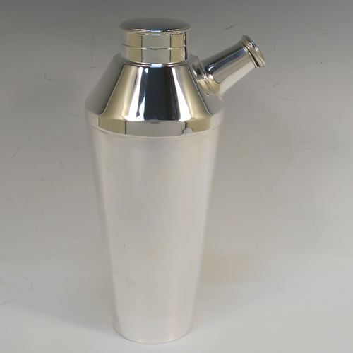 A very elegant Art Deco style Silver-Plated cocktail shaker, having a plain round body with tapering sides, with a screw-off top lid and a pull-off side pouring cap with cork stopper. This handsome silver-plated cocktail shaker was made in ca. 1930. The dimensions of this fine hand-made silver plated cocktail shaker are height 25 cms (9.75 inches), and diameter at widest point 10 cms (4 inches).   