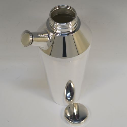 A very elegant Art Deco style Silver-Plated cocktail shaker, having a plain round body with tapering sides, with a screw-off top lid and a pull-off side pouring cap with cork stopper. This handsome silver-plated cocktail shaker was made in ca. 1930. The dimensions of this fine hand-made silver plated cocktail shaker are height 25 cms (9.75 inches), and diameter at widest point 10 cms (4 inches).   